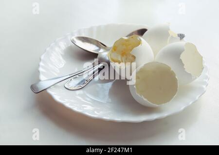 Ende des Morgenmahls der weich gekochten Eier in eleganten Teller, mit drei Teelöffel darauf Stockfoto