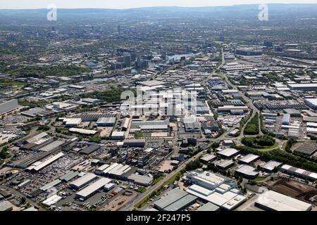 Luftaufnahme des riesigen Trafford Park Industrial Estate mit Skyline von Manchester im Hintergrund Stockfoto