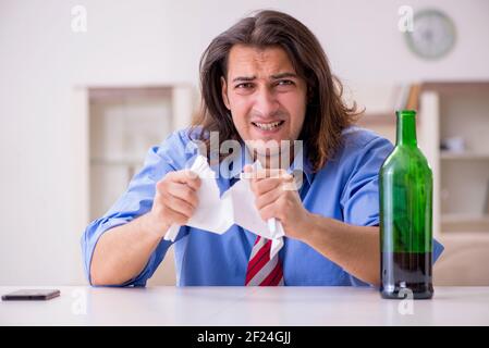 Junger männlicher Angestellter, der von seiner Arbeit zu Hause entlassen wurde Stockfoto