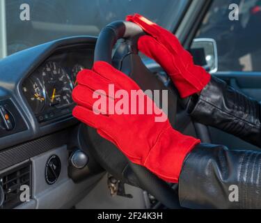 Frau Hände in Lederhandschuhen am Lenkrad. Winter Mode Hintergrund. Stockfoto