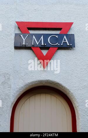 YMCA (Young Men's Christian Association) Schild an der weißen Wand in der Stadt Sidmouth, Devon Stockfoto