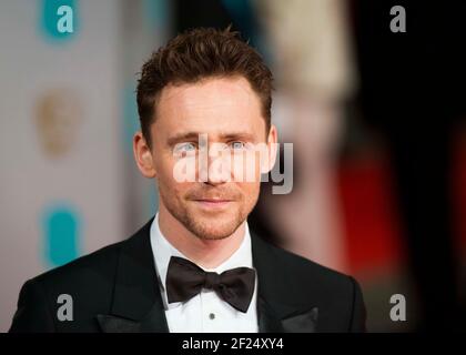 Tom Hiddlestone kommt bei den EE British Academy Film Awards 2015 im Royal Opera House, Covent Garden - London an Stockfoto