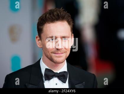 Tom Hiddlestone kommt bei den EE British Academy Film Awards 2015 im Royal Opera House, Covent Garden - London an Stockfoto