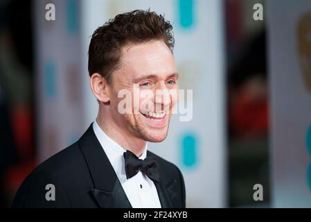 Tom Hiddlestone kommt bei den EE British Academy Film Awards 2015 im Royal Opera House, Covent Garden - London an Stockfoto