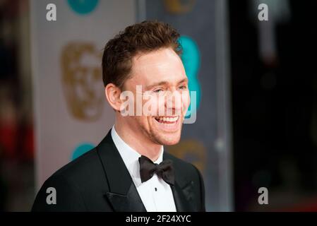 Tom Hiddlestone kommt bei den EE British Academy Film Awards 2015 im Royal Opera House, Covent Garden - London an Stockfoto