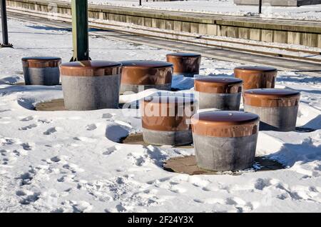 Den Haag, Niederlande, 13. Februar 2021: Sitzelemente wie Betonpuffelemente auf einer der schneebedeckten Plattformen der HS Station auf einem sonnigen Wein Stockfoto