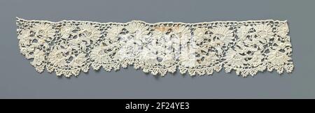 Strook gehakte kant met waaiervormige bloemen.Streifen natürlich gefärbte irische Häkelseite. Muster mit Flügelrad-förmigen Blüten mit Stielen und einem gehäkelten unregelmäßigen maase-Boden mit Picots. Die Oberseite ist mit einer geraden Kante fertig. Die halbkreisförmigen Schutze am unteren Rand werden mit abgesetzten Bögen abgelagert. Stockfoto