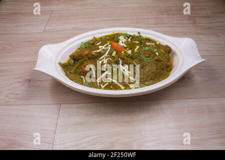 Vorspeise sautierten Knoblauch Spinat Gericht in Tasse, gebackenes Brot Scheibe mit geschmolzenem Käse auf schwarzem Stein serviert Stockfoto