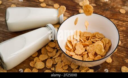 Gesunde Ernährung Hintergrund. Trockene Flocken fallen in eine Schüssel. Stockfoto