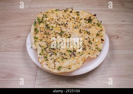 indische spezielle Fladenbrot auch als Tandoori roti oder Naan bekannt, serviert in einem weißen Keramik-Viertel Teller Stockfoto