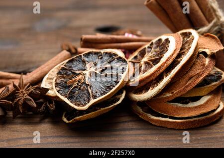 Zimtstangen und trockene Orangenscheiben auf braunem Holzbrett Stockfoto