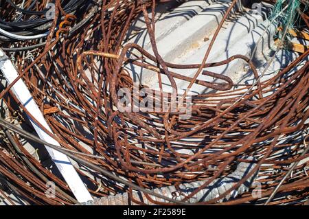 Verschwommenes Fragment eines Skein aus alter rostiger Drahtnahaufnahme. Schrottkippe. Wiederverwendung von Metall. Stockfoto