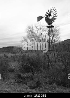 Rosting 19th Jahrhundert Windmühle außerhalb Marfa, Texas sitzt in trockenen Wüstenfeld Stockfoto