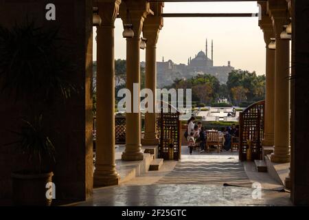 Menschen essen in einem Restaurant in Al Azhar Park mit Kairo Zitadelle im Hintergrund, Salah Salem St, El-Darb El-Ahmar, Kairo, Ägypten Stockfoto