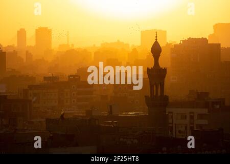 Kairos Stadtbild bei Sonnenuntergang mit der Flagge des Mannes auf der Dachterrasse, vom Al Azhar Park, der Salah Salem St, El-Darb El-Ahmar, Kairo, Ägypten aus gesehen Stockfoto