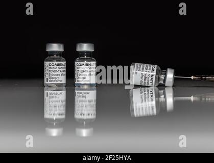 PRAG, CZE - 10. März 2021. COVID-19 SARS-Virus-Impfampullen. COMIRNATY mRNA-Impfstoff auf weißem Hintergrund. Spritze mit COMIRNATY-Impfstoff gegen S Stockfoto