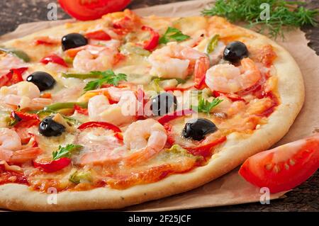 Pizza mit Garnelen, Lachs und Oliven Stockfoto