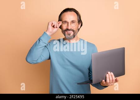 Porträt eines Unternehmers mittleren Alters in Brille mit Laptop lächelnd Isoliert auf pastellbeigem Hintergrund Stockfoto