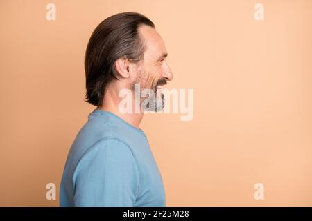 Foto Portrait Seitenprofil von reifen Mann isoliert auf Pastell Beigefarbener Hintergrund Stockfoto