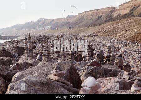 Strandküste mit Hunderten von balancierenden Steinen oder balancierten Felsen, die von der Öffentlichkeit in Barton on Sea während der Covid-Krise als cairns gestapelt wurden. Stockfoto