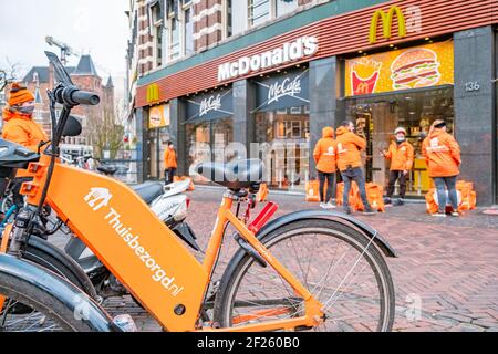 Utrecht Niederlande Thuisbezorgd und Deliveroo Food Kuriers warten in Utrecht, Niederlande. Die Lieferung von Fahrradfutter ist in U beliebt Stockfoto