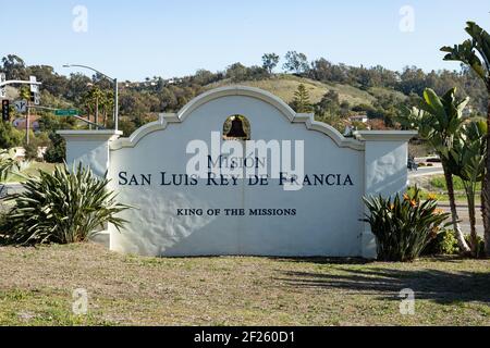 Oceanside, California USA - 5. März 2021: Eingangsschild mit Wegweiser zur Old Mission San Luis Rey, Kirche und Gebäuden im Hintergrund Stockfoto