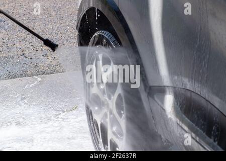 Autowäsche auf einer kontaktlosen Autowäsche. Ein Mann wäscht das Auto. Bringen Sie das Auto in Ordnung Stockfoto