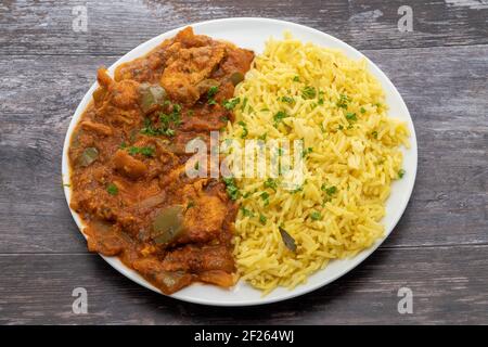 Hähnchen Jalfrezi mit Pilau-Reis auf einem weißen Teller serviert Stockfoto