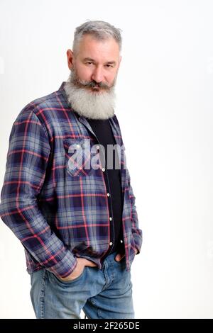 Studio Porträt von reifen bärtigen Mann in lässiger Kleidung Blick auf Kamera, informellen Lebensstil, gelber Hintergrund. Stockfoto