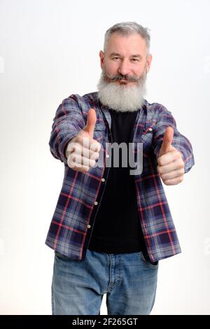 Studio Porträt reifen bärtigen Mann in lässiger Kleidung gekleidet zeigt Daumen nach oben, erfolgreiches Konzept, weißer Hintergrund Stockfoto