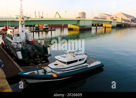 Festgemacht Guardia Civil Boote an einem ruhigen Morgen im Maliano Dock mit einer grünen Brücke Santander Cantabria Spanien Winter Stockfoto