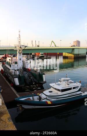 Festgemacht Guardia Civil Boote an einem ruhigen Morgen im Maliano Dock mit einer grünen Brücke Santander Cantabria Spanien Winter Stockfoto