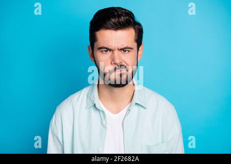 Foto von verärgert wütend jungen Mann tragen Casual Hemd schlecht Stimmungskonflikt isoliert auf blauem Hintergrund Stockfoto