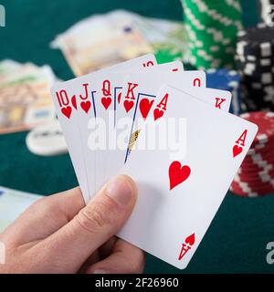 Hand des Mannes hält Royal Flush im Pokerspiel Stockfoto