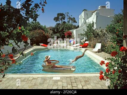 Historisches Archiv 1985 Ansicht aller Zutaten für ein erfolgreiches portugiesisches Modell veröffentlicht Familienpaket Sonnenschein Villa Urlaub in Die Algarve mit schönem private1980er-m-Swimmingpool und Gartenblumen in heißem blauen Himmel, sonniges Sommerwetter, Mietwagen Weißes, cooles, modernes Mietshausgebäude mit Mama, die sich auf den Sonnenliegen am Pool entspannen, Teenager, der taucht und nervt Meine Tochter sonnte sich auf einem schwimmenden Sessel, Lilo, und Dad machte 80s Archivfotos in einem „Way we were“-Bild, das es auch gab Fast alles für Auslandsreisen in Portugal Stockfoto