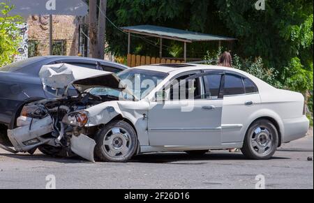 Zwei Autos auf der Straße nach der Kollision. Beschädigtes weißes Auto auf der Straße nach dem Unfall Stockfoto