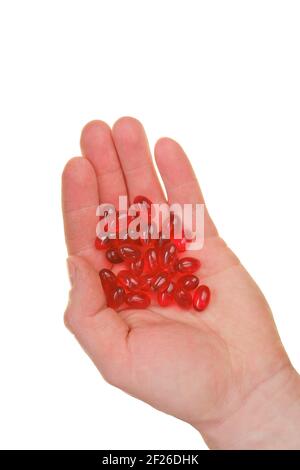 Krillöl-Kapseln. Rote Gelatine Kapseln mit Krillöl in der Hand isoliert auf weißem Hintergrund.Quelle von Omega-Fettsäuren. Krillöl Ergänzungen Stockfoto