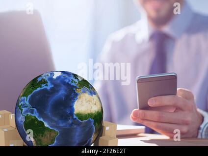 Zusammensetzung von Kartons mit Globus und Geschäftsmann mit Smartphone Und mit Laptop Stockfoto