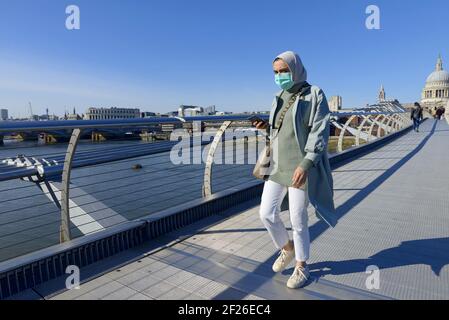 London, England, Großbritannien. Musselin-Frau mit Gesichtsmast auf der Millennium Bridge während der COVID-Pandemie, März 2021 Stockfoto