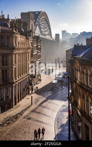 Newcastle upon Tyne's Quayside, Tyne Bridge und Grainger Town sind bei Sonnenaufgang golden gefärbt mit einem leichten Nebel über dem Fluss Stockfoto