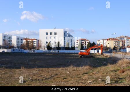 Orange Digger parkte innerhalb der Wohnungen Stockfoto