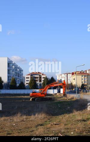 Orange Digger parkte innerhalb der Wohnungen Stockfoto