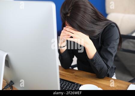 Verärgerte Frau beugte ihren Kopf vor dem Monitor Stockfoto