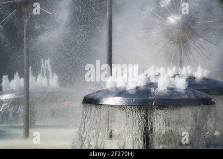 Wasser Spiele in einem Brunnen. Wasserauslauf-Brunnen mit Nebel, aus Edelstahl, pilzförmig, Wasserstrahl, sprudelnd. Wasserspiele Stockfoto