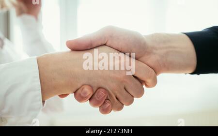 Händeschütteln, Konzept für Teamarbeit: Nahaufnahme von Mann und Frau, die im Büro die Hände schütteln Stockfoto