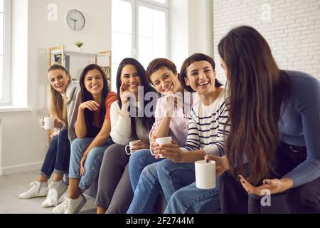 Gruppe von glücklichen jungen Frauen, die Kaffee genießen und zuhören Die Geschichten der anderen Stockfoto