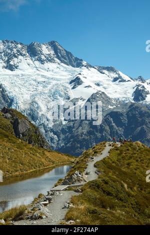 Wanderer durch Sealy Tarns, und Mt Sefton, Aoraki / Mount Cook National Park, South Island, Neuseeland Stockfoto