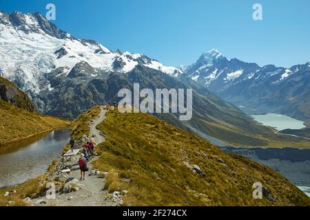 Wanderer an Sealy Tarns, Mt Sefton (links) und Aoraki / Mt Cook (rechts), Aoraki / Mount Cook National Park, South Island, Neuseeland Stockfoto