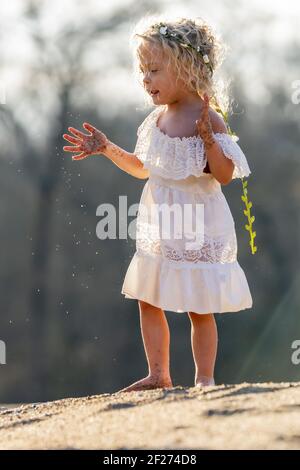 Ein schönes, blondes Kind genießt einen Frühlingstag im Freien Stockfoto