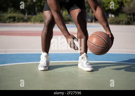 Kurzer schwarzer Sportler Dribbbling Basketball Ball Stockfoto